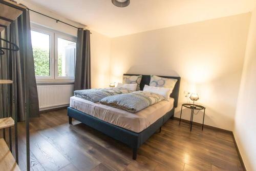1 dormitorio con cama y ventana en Südschleife Apartments - App. 3 - Direkt am Ring, en Reimerath