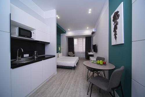 a room with a kitchen and a table with a sink at Sweet Home Apart-Hotel in Yerevan