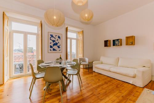 a living room with a couch and a table and chairs at RENT4REST CASTLE VIEW FAMILY & FRIENDS Bairro Alto in Lisbon