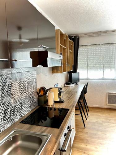 une cuisine avec un évier et un plan de travail dans l'établissement Studio MAJA proche des plages parking, à Saint-Nazaire