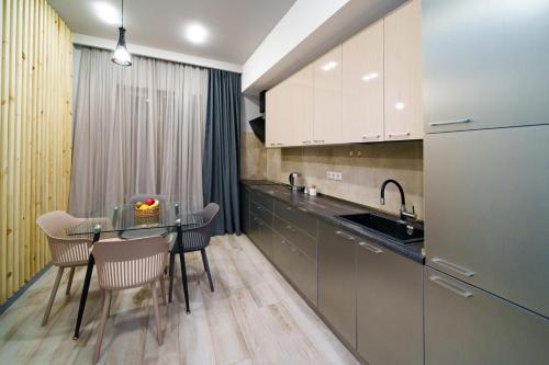 a kitchen with a table and chairs and a sink at Sweet Home Apart-Hotel in Yerevan