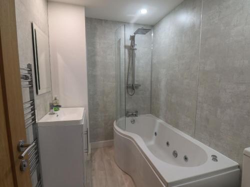 Baño blanco con bañera y lavamanos en Frankies Seaview 3, en Bridlington