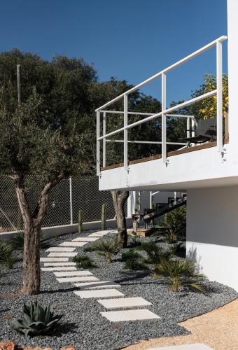 a building with a walkway next to a tree at Boutique Hotel - Casa Esteval in Rocha Amarela