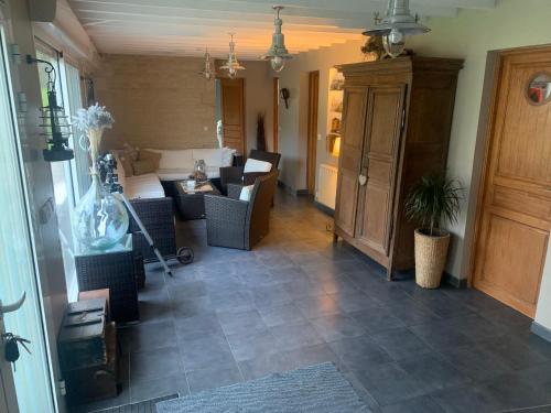 - un couloir avec un salon doté d'un canapé et d'une table dans l'établissement Sur les Routes du Débarquement - Chambre Quadruple -, à Bavent