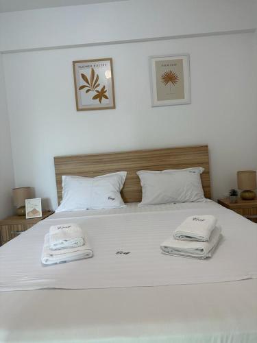 a white bed with two towels on top of it at Cozy Holidays in Center of Suceava Esplanada in Suceava