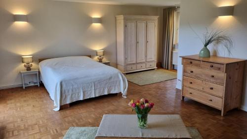 a bedroom with a bed and a dresser and a table at Ferienhaus Corinna Bisping in Ollsen