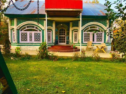 una casa verde y blanca con techo rojo en Habib Guest House (Gulmarg), en Gulmarg