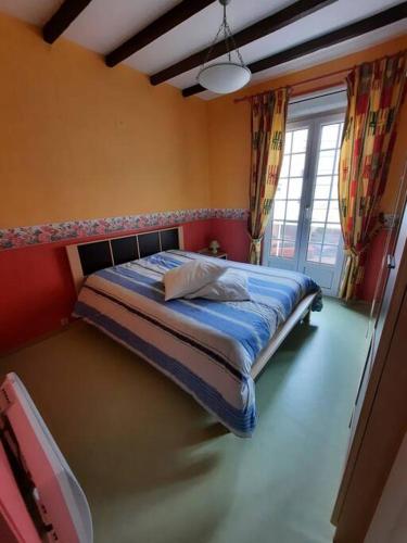 une chambre avec un lit dans une pièce avec une fenêtre dans l'établissement Maison Les Cordiers, au Tréport
