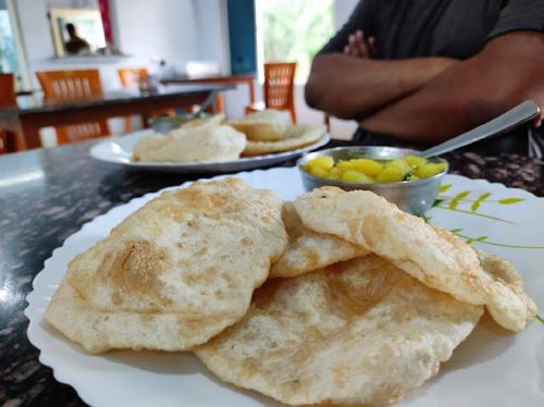 ein weißer Teller mit etwas Essen auf einem Tisch in der Unterkunft Sea Wave Beach Resort in Tajpur