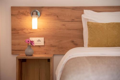 キサモスにあるKaliviani Traditional Hotelのベッドルーム1室(ベッド1台付)、花瓶1本(テーブル上)