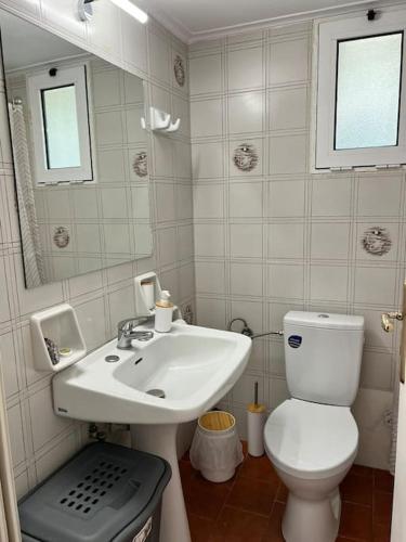 a bathroom with a white toilet and a sink at Marvel City Studio in the centre in Rethymno