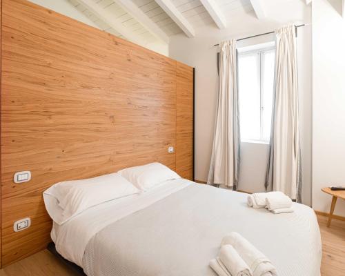 een slaapkamer met een groot bed met een houten hoofdeinde bij White Moon crema & Parking in Crema