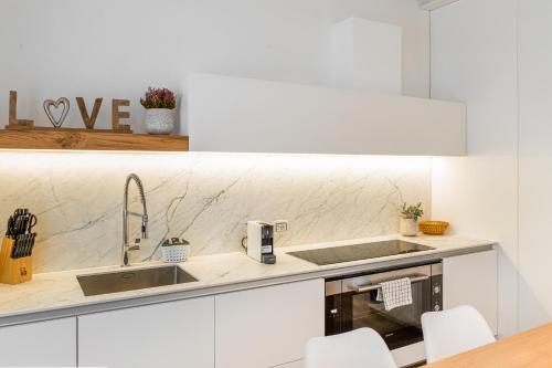 a white kitchen with a sink and a counter at White Moon crema & Parking in Crema