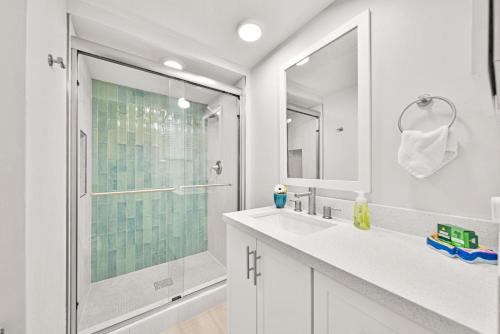 a white bathroom with a shower and a sink at Loggerhead Cay #434 in Sanibel