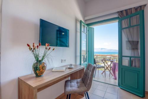 a room with a table with a vase of flowers on it at Kaliviani Traditional Hotel in Kissamos