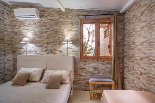 a bedroom with a bed and a brick wall at Villa Gaudì - Batllò in Sant'Isidoro