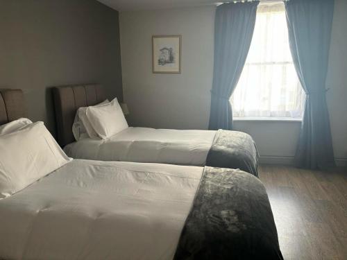 a hotel room with two beds and a window at The Victorian Tap in Hexham