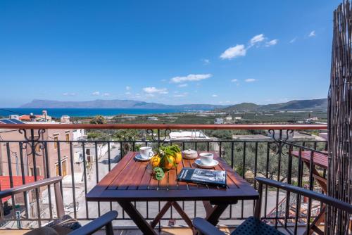 a table on a balcony with a view of the ocean at Kaliviani Traditional Hotel in Kissamos