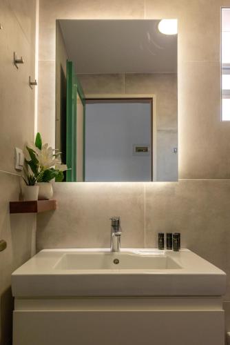 a bathroom with a white sink and a mirror at Kaliviani Traditional Hotel in Kissamos