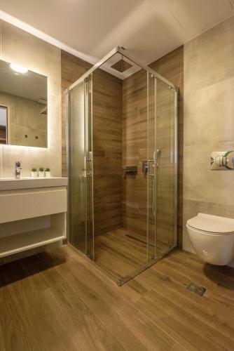 a bathroom with a shower with a toilet and a sink at Kaliviani Traditional Hotel in Kissamos