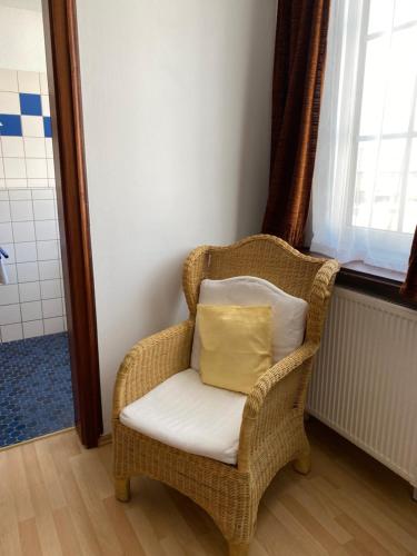 a wicker chair with a pillow in a bathroom at Rheinischer Hof in Pfungstadt
