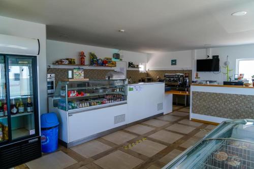 a kitchen with an open refrigerator and a counter at Kampaoh Peniche in Ferrel