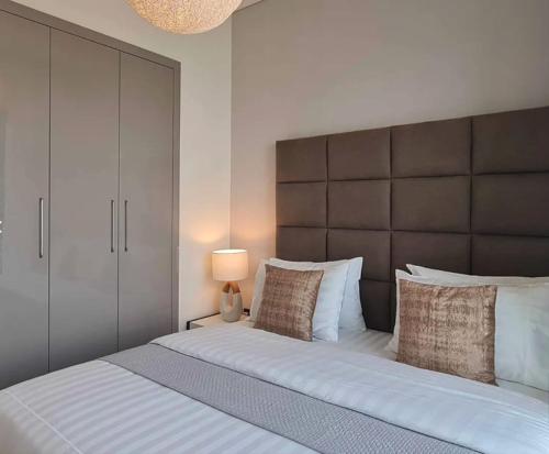 1 dormitorio con 1 cama grande y cabecero grande en Azizi Riviera Small Family Private Apartment Dubai en Dubái