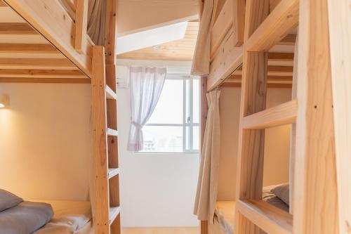a room with bunk beds and a window at ONE Miyakojima in Miyako Island