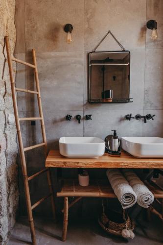 La salle de bains est pourvue de 2 lavabos et d'un miroir mural. dans l'établissement Bergerie de luxe Pietra Rossa, à Serra-di-Ferro