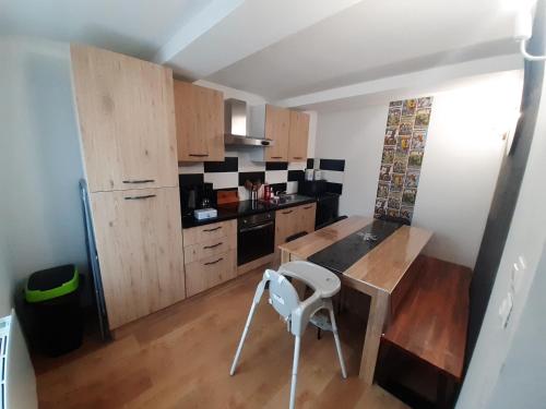 a kitchen with wooden cabinets and a white chair in it at Les 4 Fils Aymon in Bogny Sur Meuse