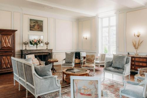 un salon avec des chaises et une cheminée dans l'établissement Château de Marigné - Gîte de charme- 15 pl, à Cré-sur-Loir