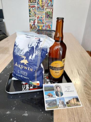 a bottle of beer and a bag of alcohol on a table at Les 4 Fils Aymon in Bogny Sur Meuse