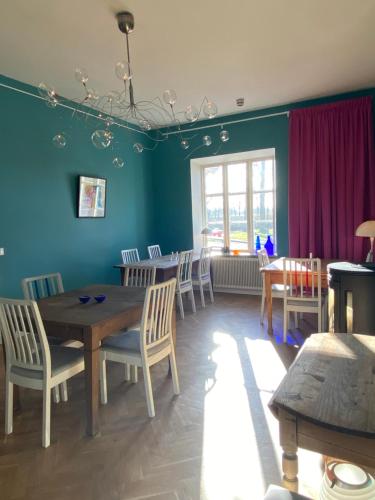 a dining room with blue walls and a table and chairs at Tastecelebration Residence in Andrarum-Brosarp