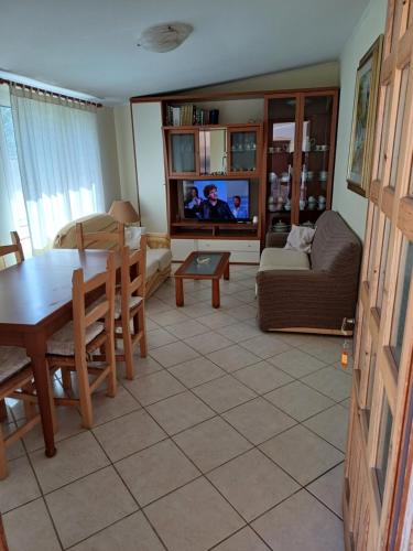 Una sala de estar con una mesa, un sofá y un televisor. en CASA ELIDA al Centro, en Santa Maria Navarrese