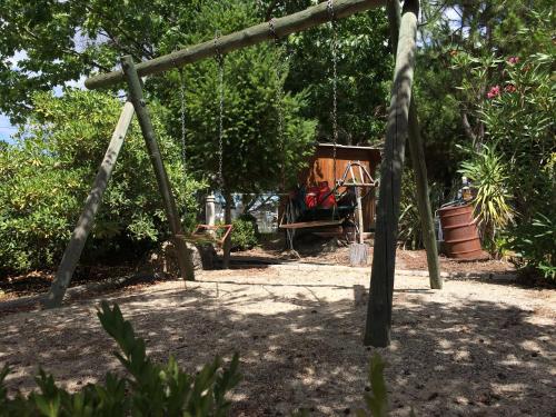 an old swing set in a yard with trees at Quinta Formosa in Vale Formoso