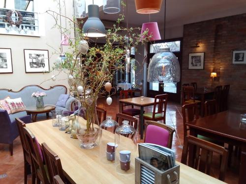 a table with a vase of flowers on it at Hotel Stare Miasto Old Town in Poznań