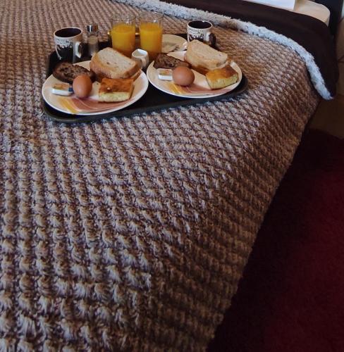 a tray with two plates of food on a bed at Erodios Guesthouse in Kato Loutraki