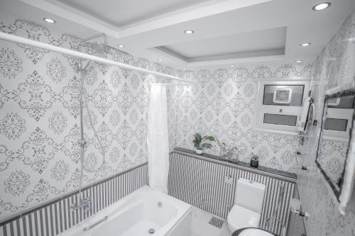 ein Badezimmer mit einer Badewanne, einem WC und einem Waschbecken in der Unterkunft Platinum One Story Villa , 350 m , Heliopolis in Kairo