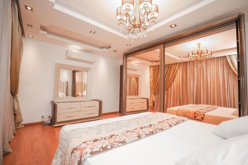 1 Schlafzimmer mit 2 Betten und einem Kronleuchter in der Unterkunft Platinum One Story Villa , 350 m , Heliopolis in Kairo