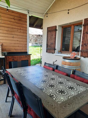 - une table et des chaises sur une terrasse avec une cheminée dans l'établissement Le jardin de Moun, à Villy-le-Bouveret