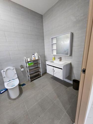 a bathroom with a white toilet and a sink at World Peace in Kampong Bantun