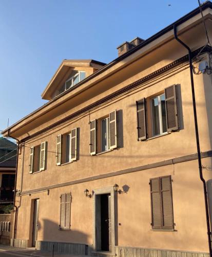 un edificio antiguo con ventanas con persianas y una puerta en San Martino Holiday Apartments, en Nizza Monferrato