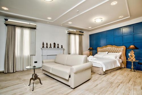 a bedroom with a white couch and a blue wall at 50th Guest House in Vittoriosa