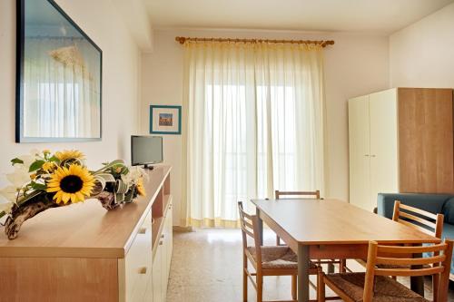 a kitchen and dining room with a table with a sunflower centerpiece at Tourist Residence in San Benedetto del Tronto