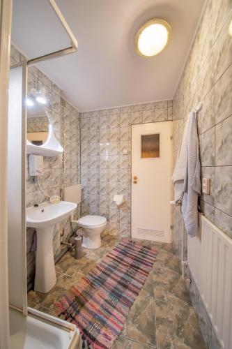 a bathroom with a sink and a toilet and a shower at Pokoje Gościnne Szpak in Białowieża