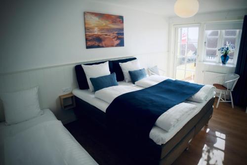 a bedroom with a large bed and a window at Plesners Badehotel in Skagen