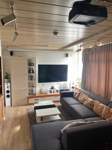 - un salon avec un canapé et une télévision dans l'établissement Beautiful romantic apartment in Rotterdam, à Rotterdam