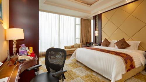 a hotel room with a bed and a desk and a chair at Soluxe Hotel Guangzhou - Overseas Buyers Registration Service&Canton Fair Free Shuttle Bus 15 Oct to 04 Nov in Guangzhou