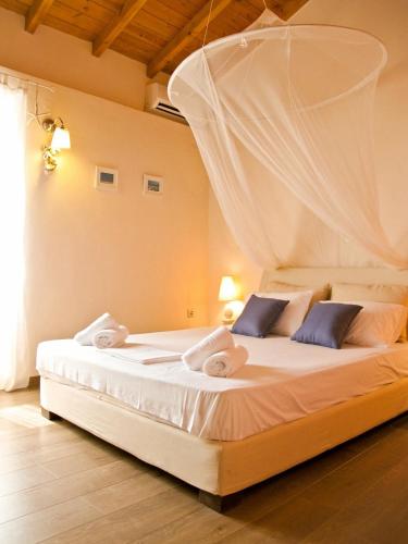 a bedroom with a bed with white sheets and pillows at Theano Cottage in Gaios