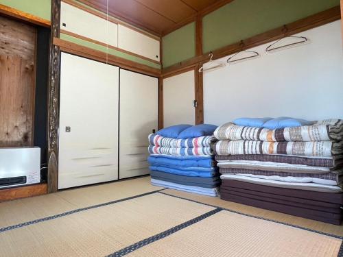 una stanza con due porte del garage e un mucchio di coperte di 農家古民家ねこざえもん奥屋敷 Nekozaemon-Gest house a Nishiwada